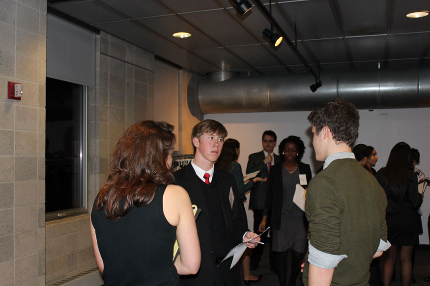 25 Senior, James Brandt Roen engages two delegates, discussing his proposed resolution